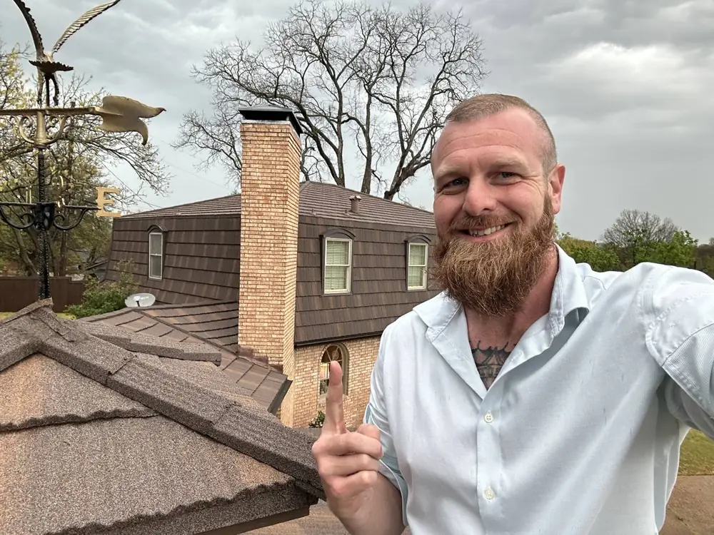 Bobby Persall, owner of Big Bob's Roof Pros, on a finished metal roof in Sherman
